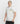 Upper body view of a model wearing the white Ariiston 'Fearless' T-Shirt